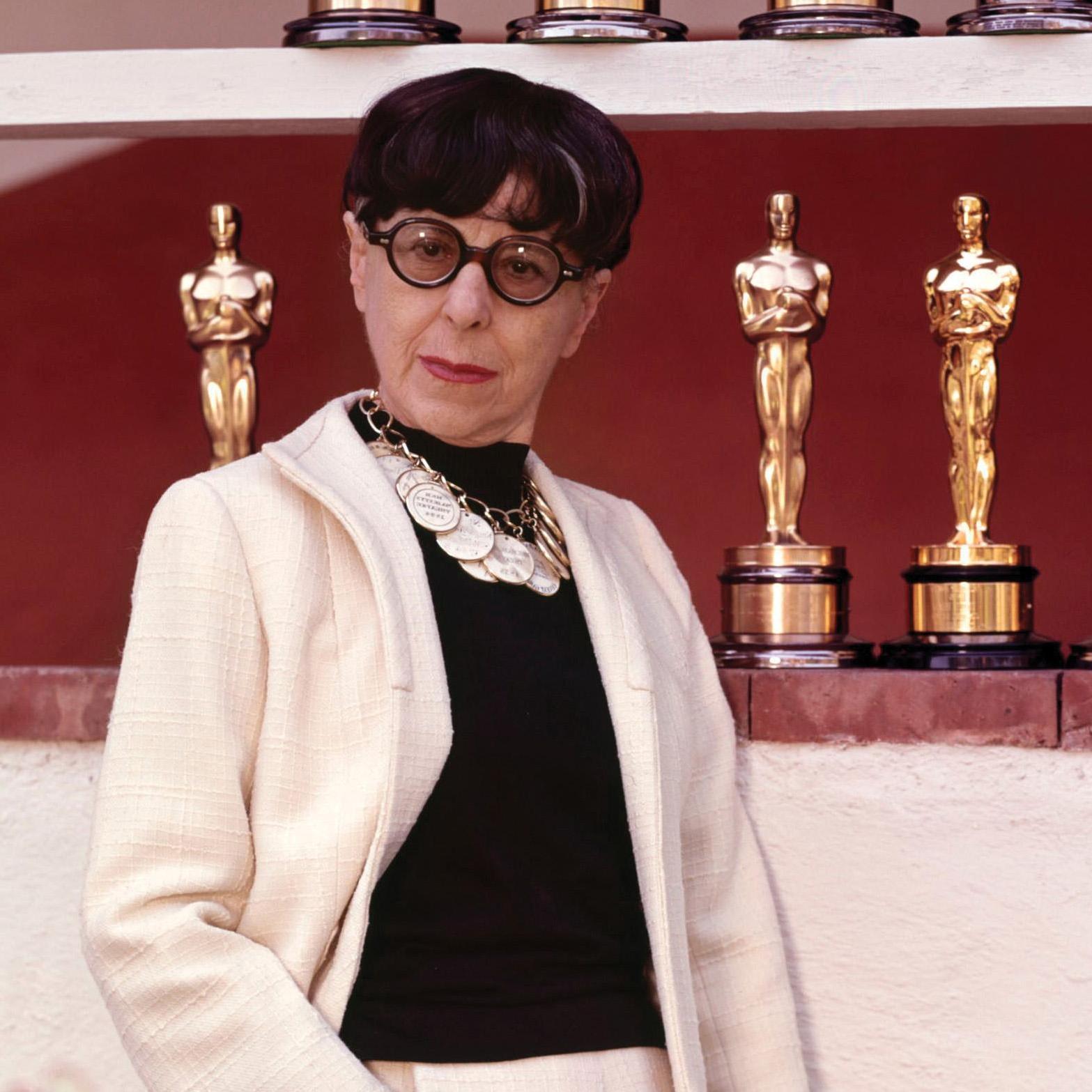 Portrait of Edith Head in front of Academy Award statuettes